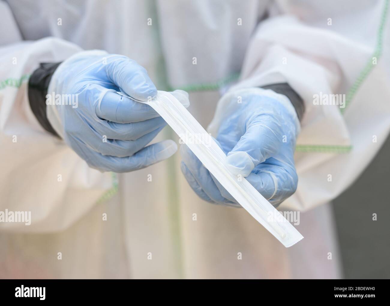 08 aprile 2020, Hessen, Francoforte sul meno: Un membro del team di test tiene un test stick per il campione di saliva. Un mobile di prova per i test della corona a livello di area è in uso presso lo Stunz Zentrum di agosto, una casa di riposo e di cura. Secondo un portavoce di Awo, 172 dipendenti e 140 residenti saranno testati. Le persone che non sono mobili verranno testate nella struttura. Foto: Andreas Arnold/dpa Foto Stock