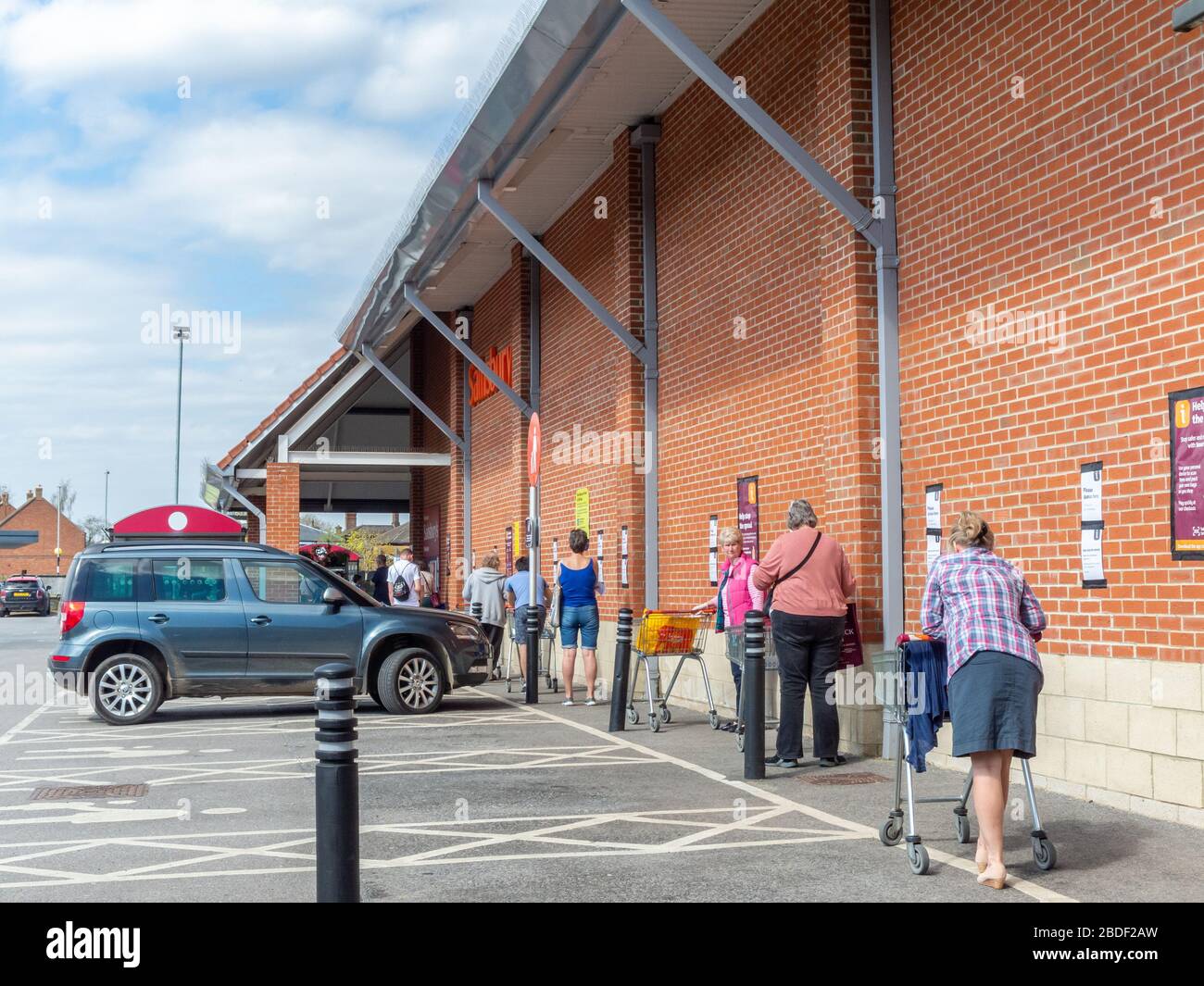 Pocklington, East Yorkshire, UK, 04/08/2020 - una coda di acquirenti presso un supermercato locale Sainsbury's mantenere la loro distanza. Foto Stock