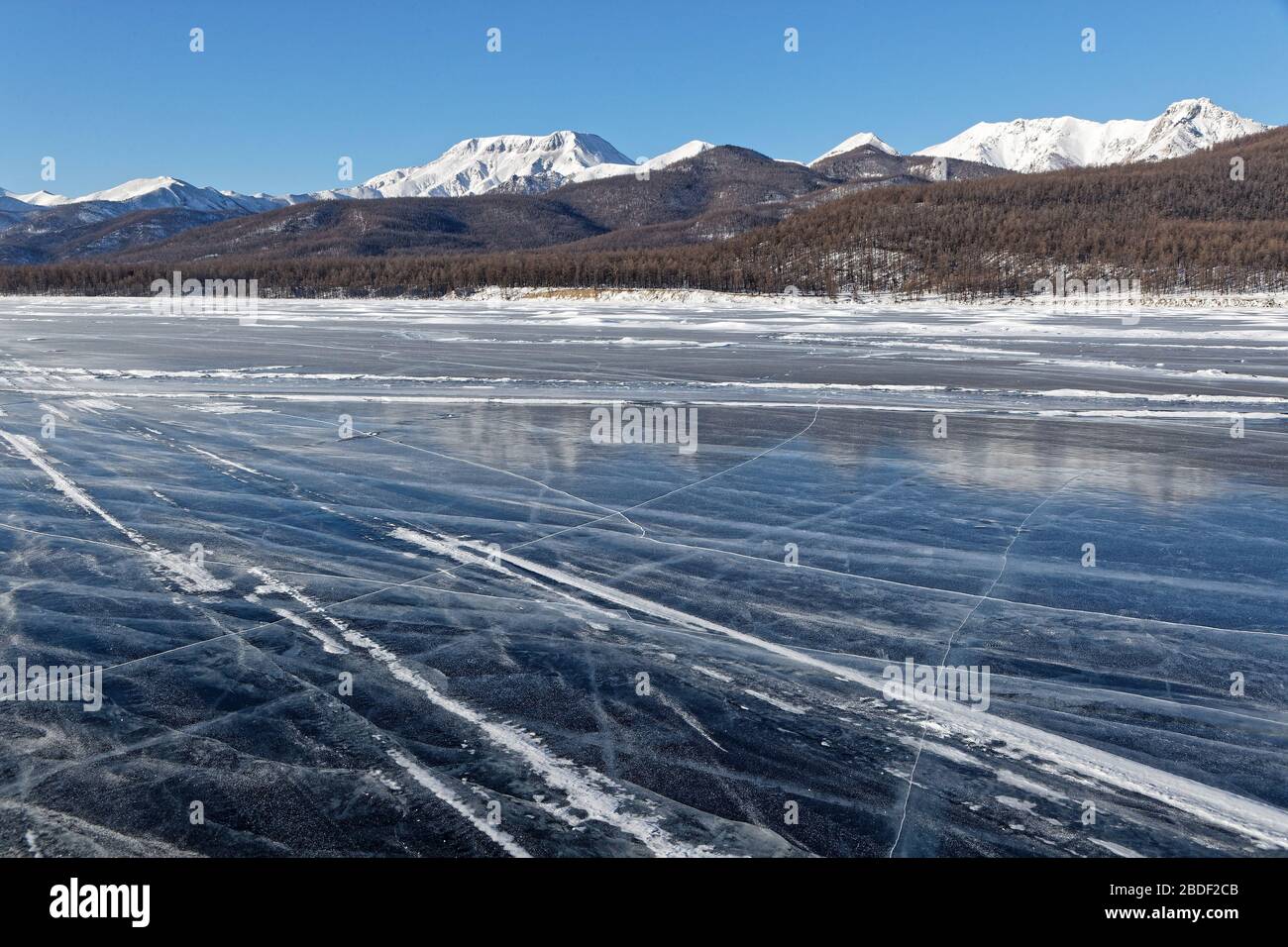 Paesaggio di montagne innevate dalla pista sul lago ghiacciato, Khovsgol, Mongolia Foto Stock