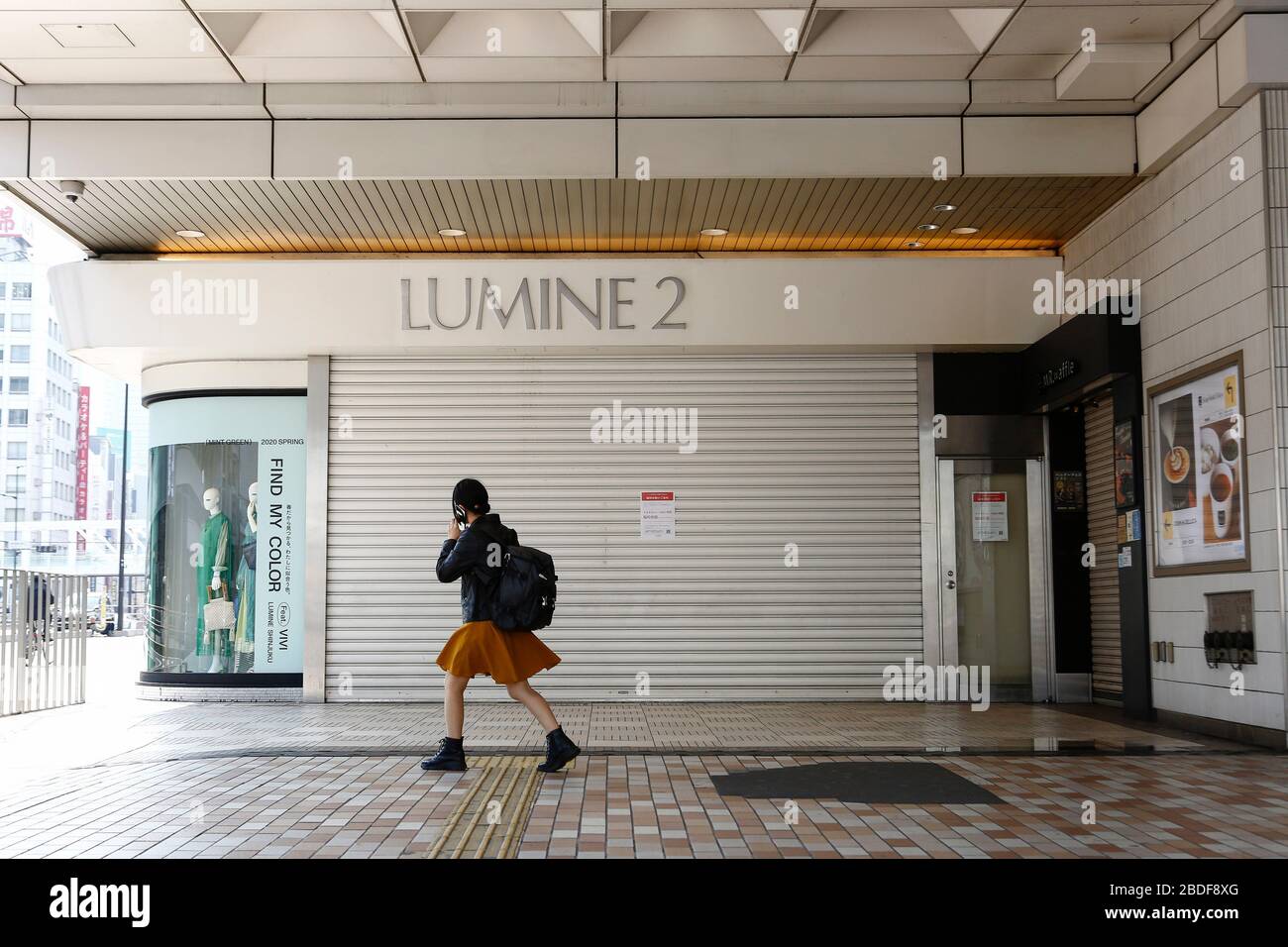 Tokyo, Giappone. 8 Aprile 2020. Una donna oltrepassa un avviso che annuncia la chiusura temporanea del centro commerciale LUMINE 2 a Shinjuku. Alcuni negozi di Tokyo hanno deciso di chiudere temporaneamente le porte dopo che il primo ministro giapponese Shinzo Abe ha dichiarato uno stato di emergenza per la capitale e altre sei prefetture del Giappone. Credit: Rodrigo Reyes Marin/ZUMA Wire/Alamy Live News Foto Stock