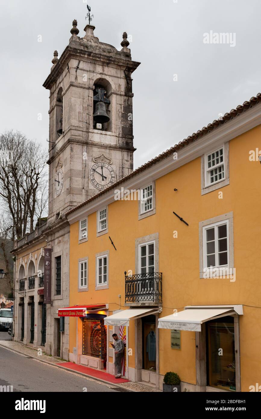 Sintra/Portogallo - Feb 12 2020: Un uomo guarda un cellulare mentre si trova fuori da una fila di negozi. Foto Stock