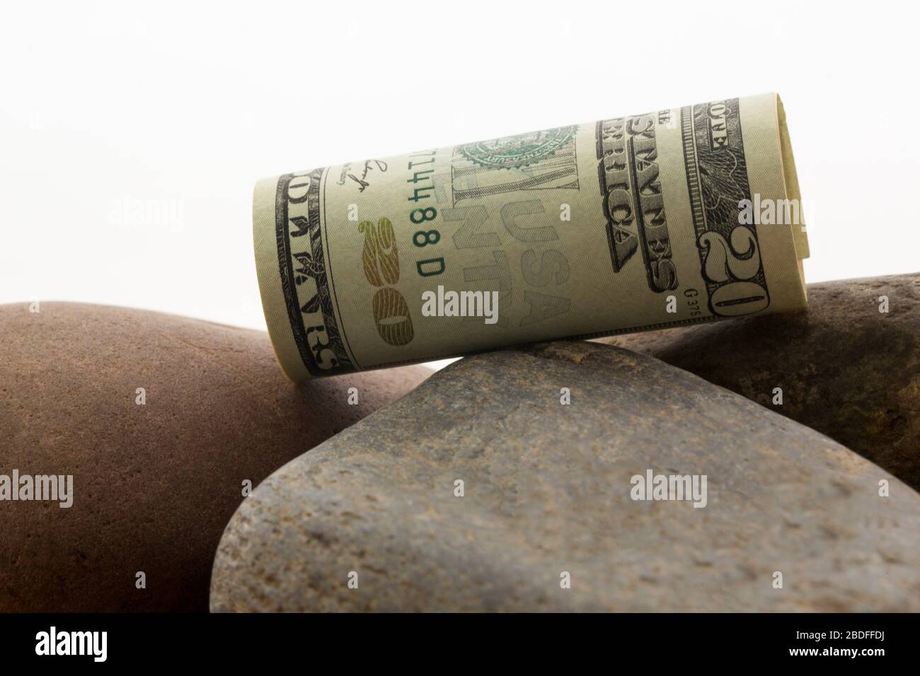 La valuta del dollaro degli Stati Uniti sulle rocce del fiume nell'immagine concettuale riflette i declini e i valori depressi di investimento Foto Stock