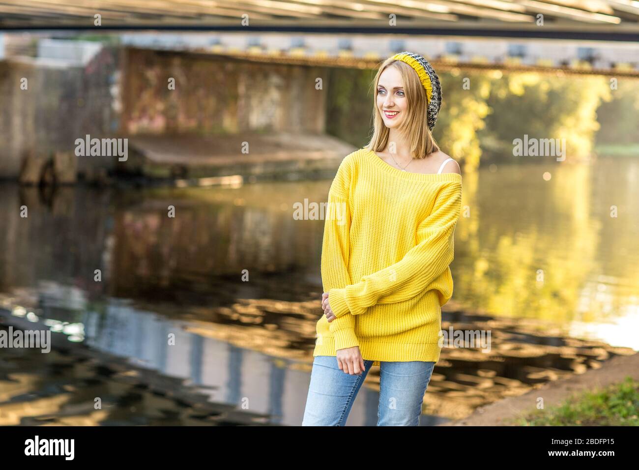 giovane donna in piedi accanto al fiume Foto Stock