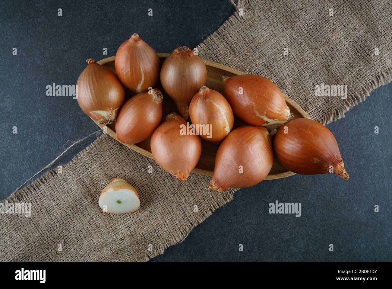 Un gruppo di cipolle su sfondo scuro Foto Stock