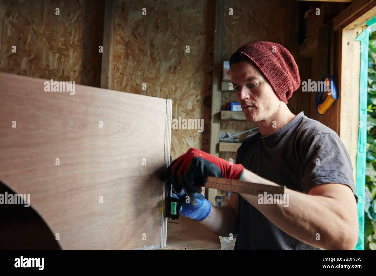 Falegname con righello per misurare oggetti di legno Foto Stock