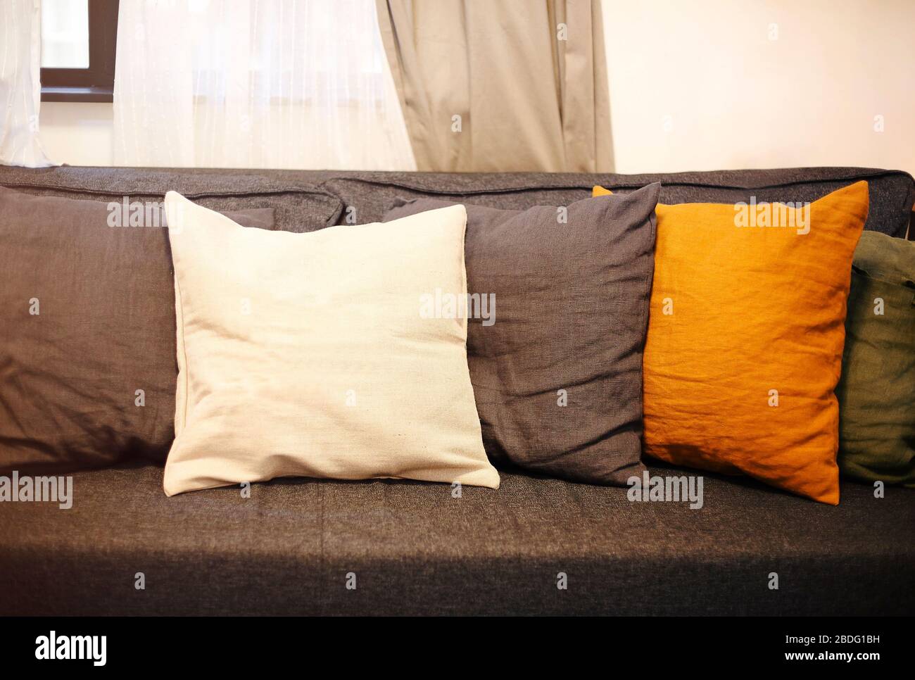 Interno soggiorno con divano grigio e cuscini gialli. Sfondo accogliente Foto Stock