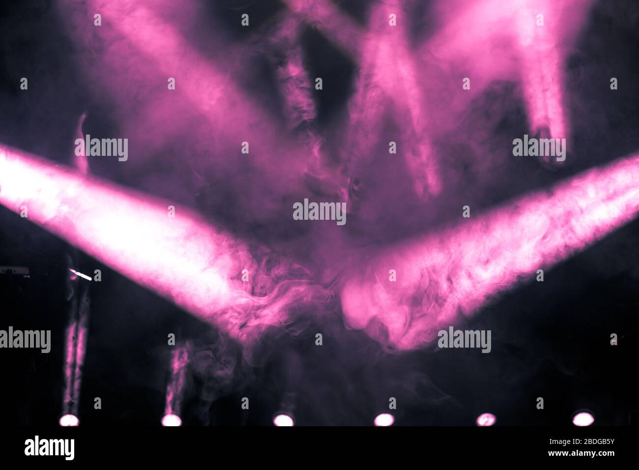 Raggio di luce rosa con faretti fumogeni e antinebbia sul palco. Sfondo  dell'attrezzatura luce di scena Foto stock - Alamy