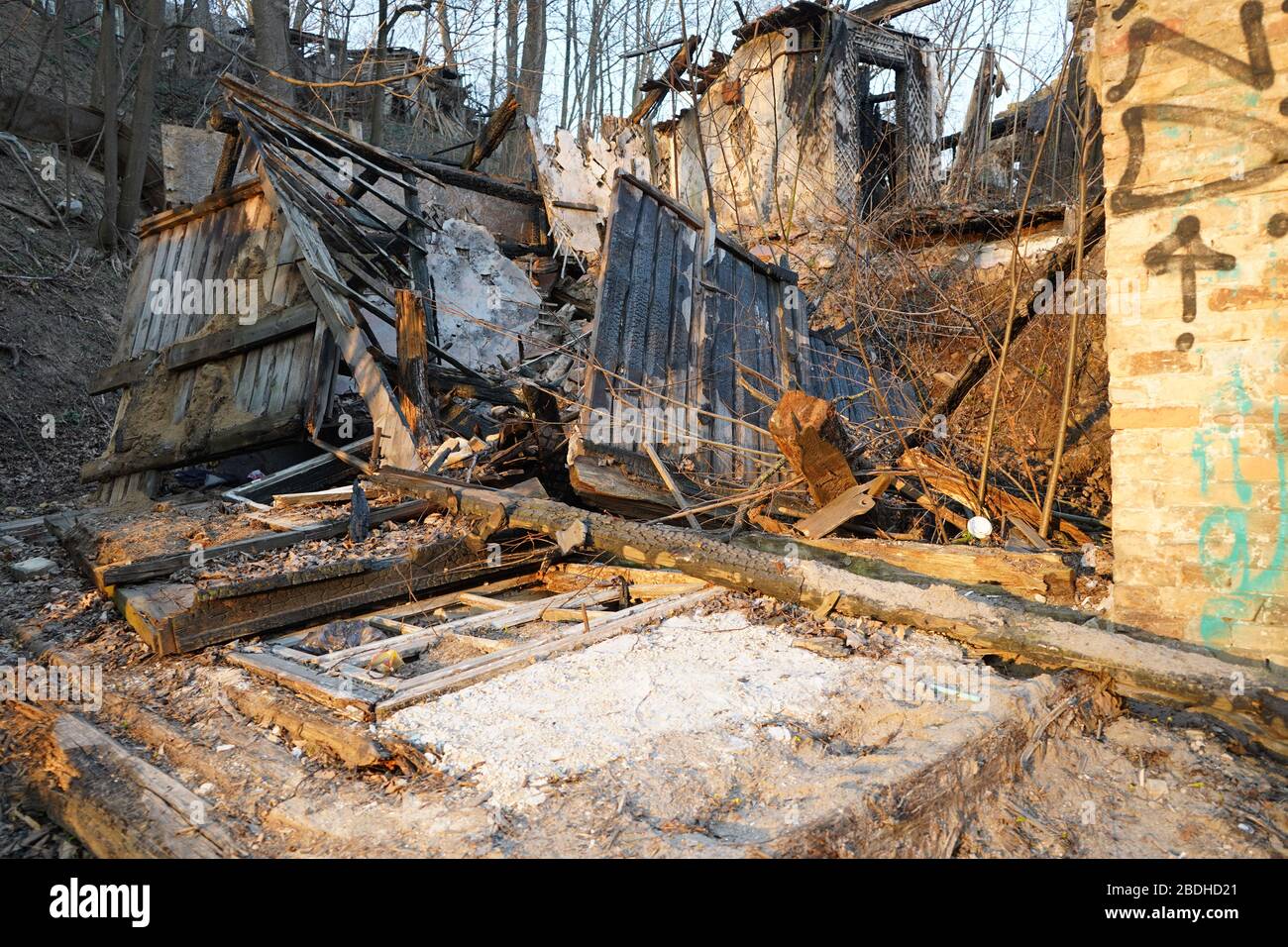 Vecchia finestra rotta che giace sul terreno dopo che la casa abbandonata si è bruciata Foto Stock