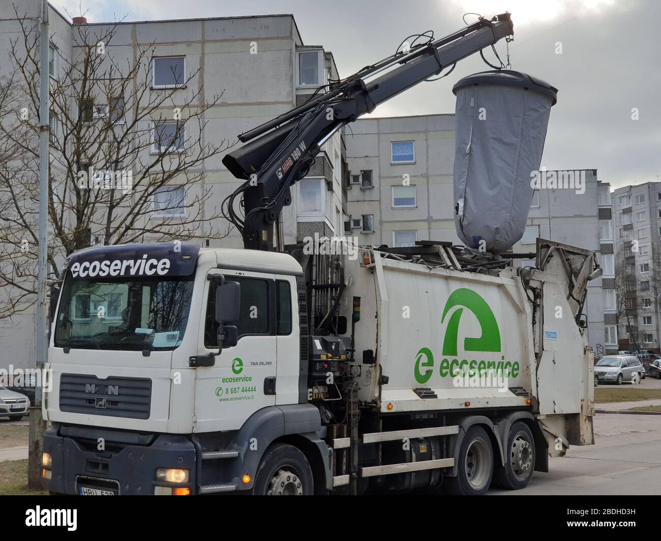 Il camion pesante sta sollevando il sacchetto enorme dei rifiuti per svuotarlo Foto Stock