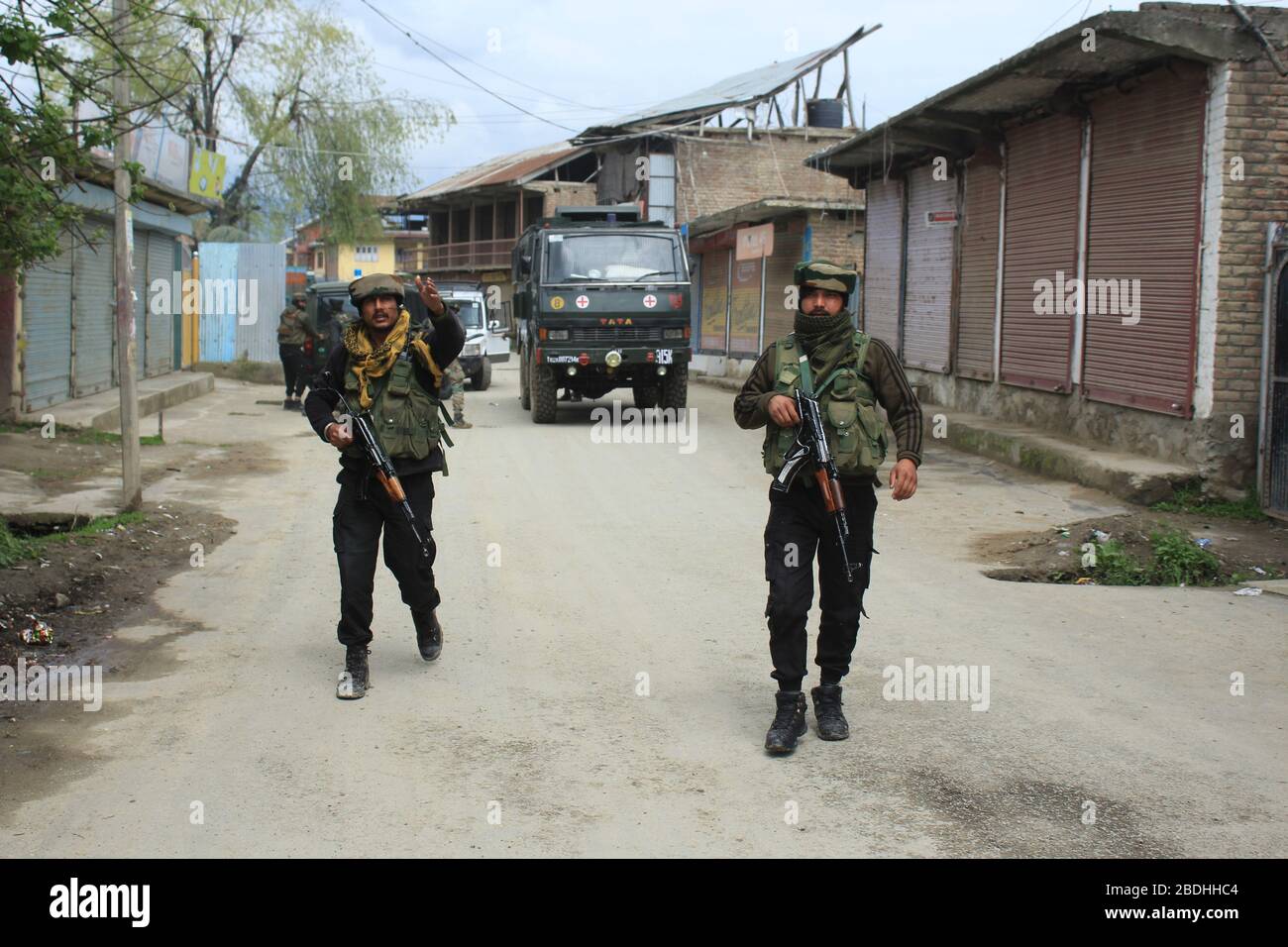 Srinagar, India. 8 aprile 2020. Personale di sicurezza che si nasconde verso il sito di Gunfight al villaggio di Sopore del distretto di Baramulla a nord di Srinagar (foto di Sajad Hameed/Pacific Press) Credit: Pacific Press Agency/Alamy Live News Foto Stock