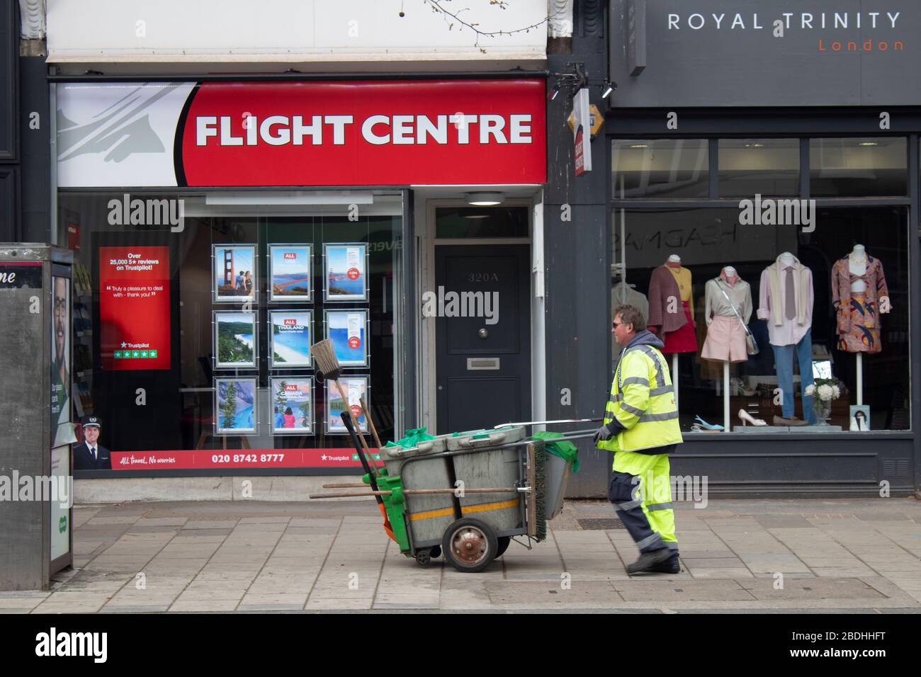 Un pulitore di strada, uno dei lavoratori chiave che continua a lavorare mentre i negozi sono chiusi e le strade vuote durante il blocco Covid-19, Chiswick London UK Foto Stock
