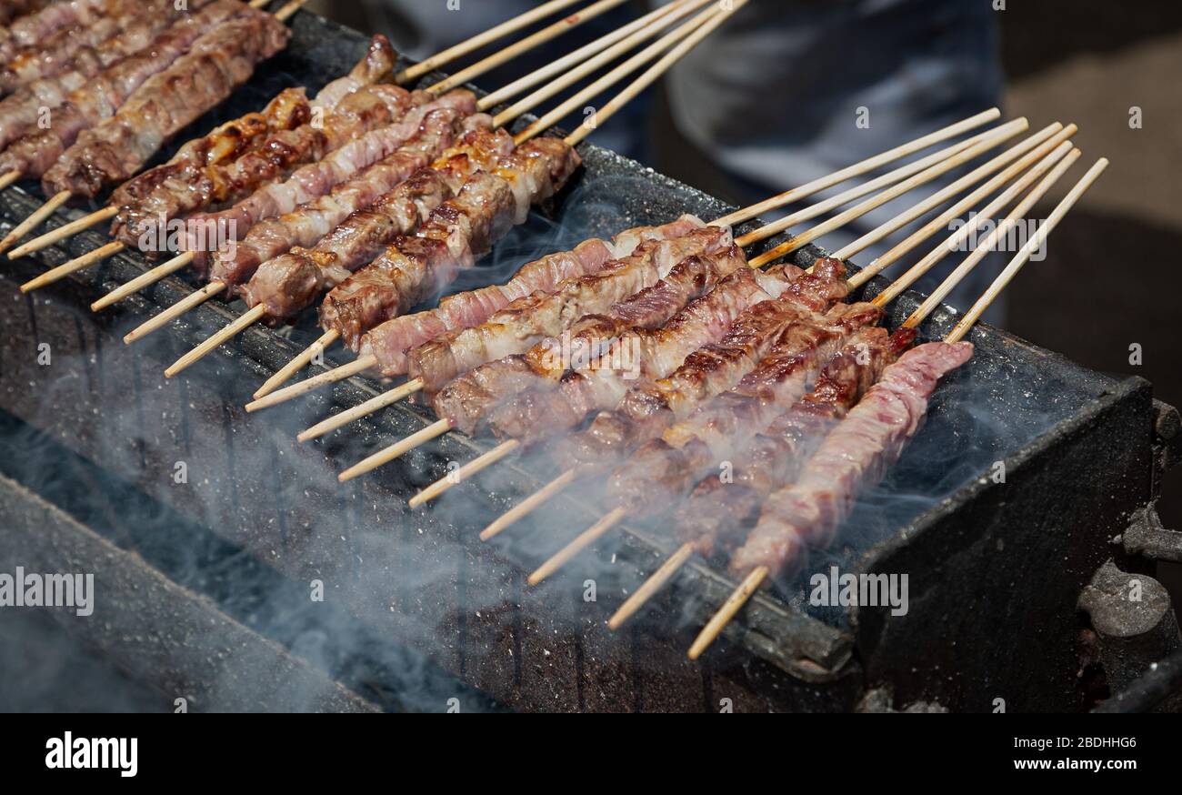 Arrosticini cucinati all'aperto, campo Imperatore, Abruzzo, Italia Foto Stock
