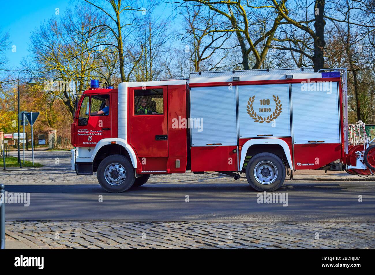 Grossziethen, Germania - 6 aprile 2020: Motore antincendio dei vigili del fuoco volontari sulla strada per un sito di distribuzione. Foto Stock