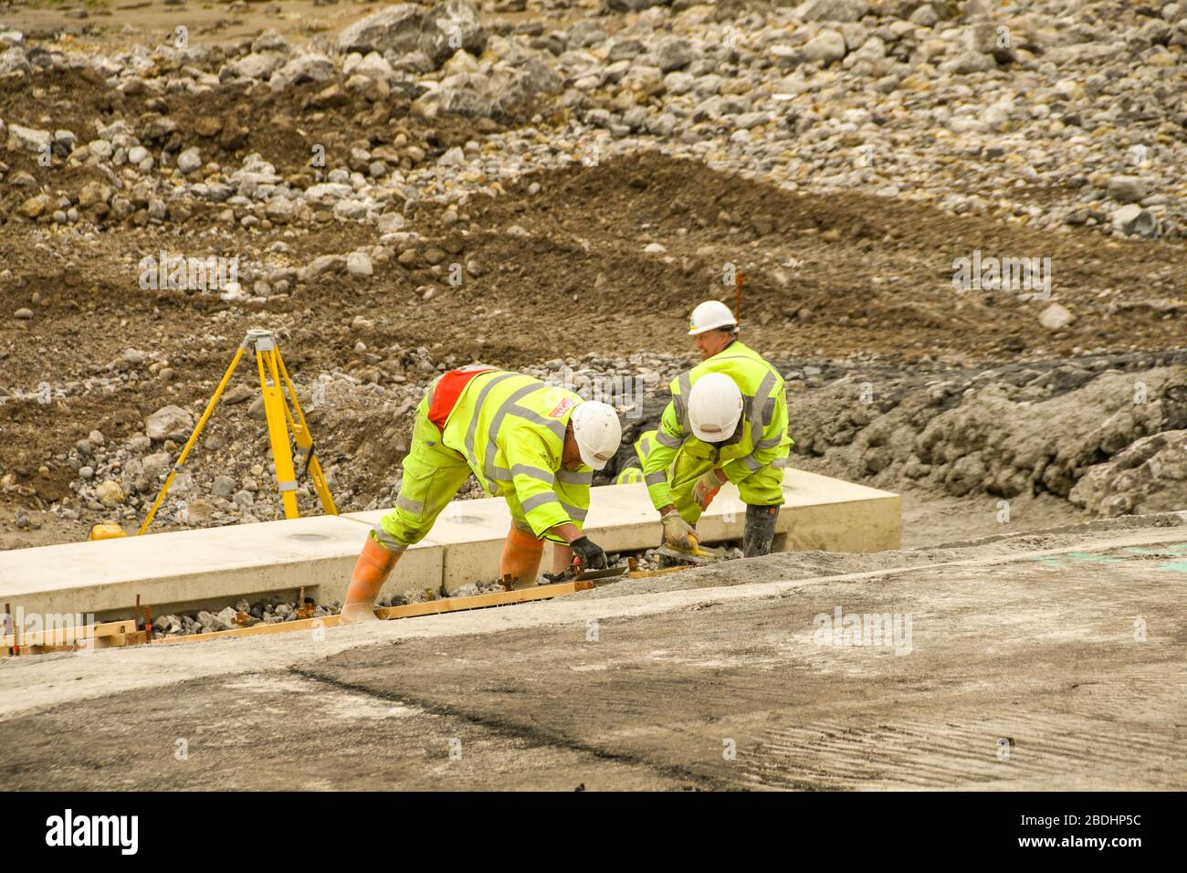 PORTHCATWL, GALLES - GIUGNO 2018: Operatori edili che posano cemento su rocce sul lungomare di Porthcatwl per migliorarne l'aspetto Foto Stock