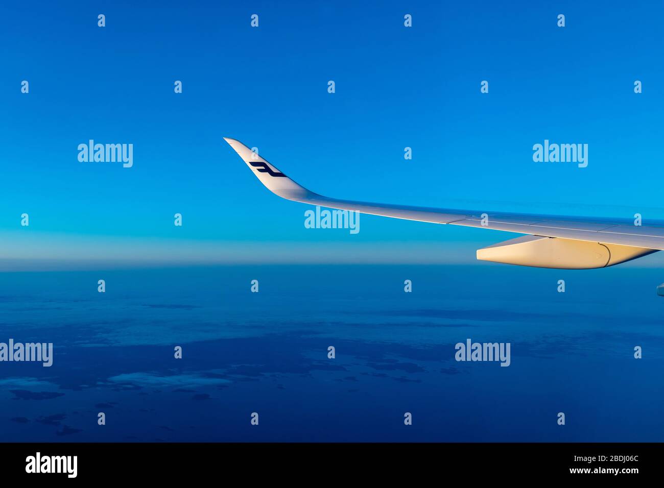Finlandia Helsinki 2 MAR 2020 Logo blu delle compagnie aeree Finnair sull'ala dell'aereo di fronte al cielo blu e all'orizzonte blu della Terra durante il tramonto Foto Stock