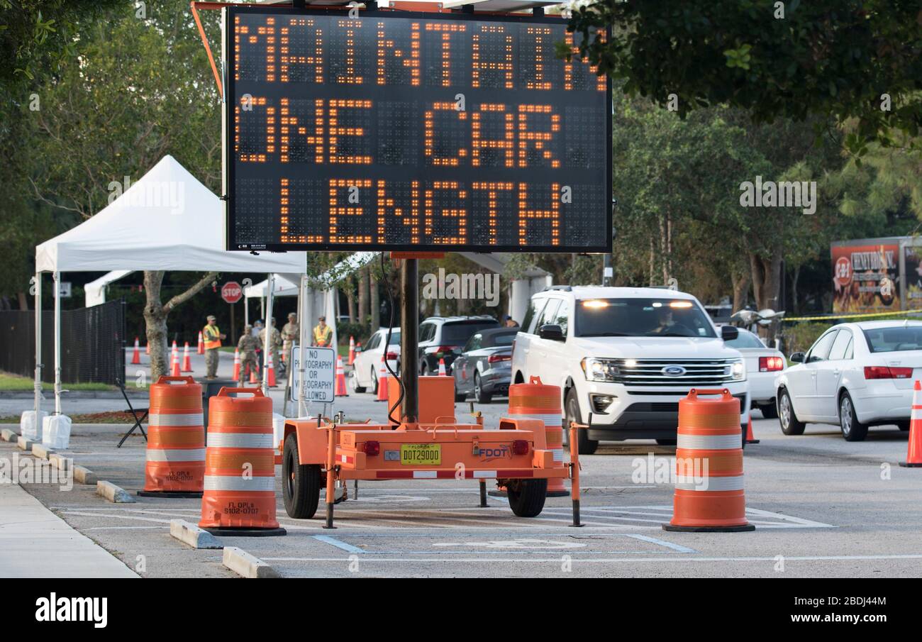 Un cartello indica i veicoli per mantenere le distanze sociali presso una stazione di test mobile COVID-19 presso il South County Civic Center 7 aprile 2020 a Delray Beach, Florida. Foto Stock