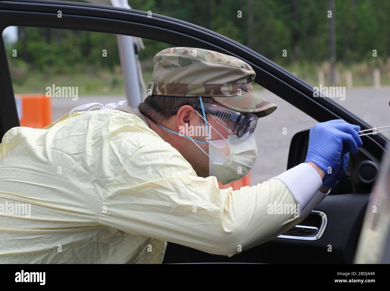 Medica di combattimento dell'Esercito degli Stati Uniti PFC. Jordan Tovarnak prende un tampone nasale da un paziente al sito di test Drive-Thru di Fort Stewart Covid-19 il 7 aprile 2020 a Fort Stewart, Georgia. Foto Stock