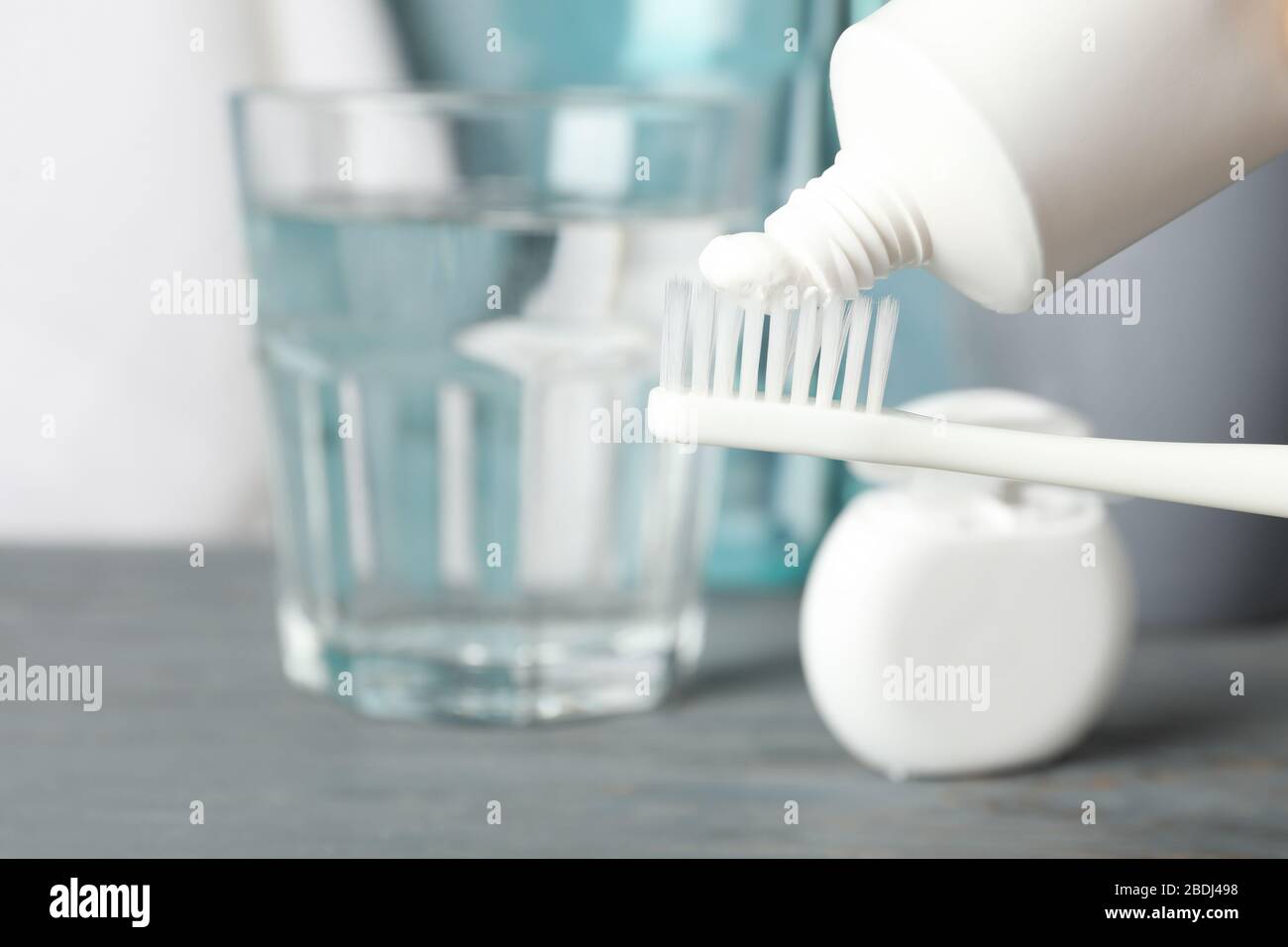 Spazzolino da denti con dentifricio sullo sfondo con strumenti per la cura dentale, primo piano Foto Stock