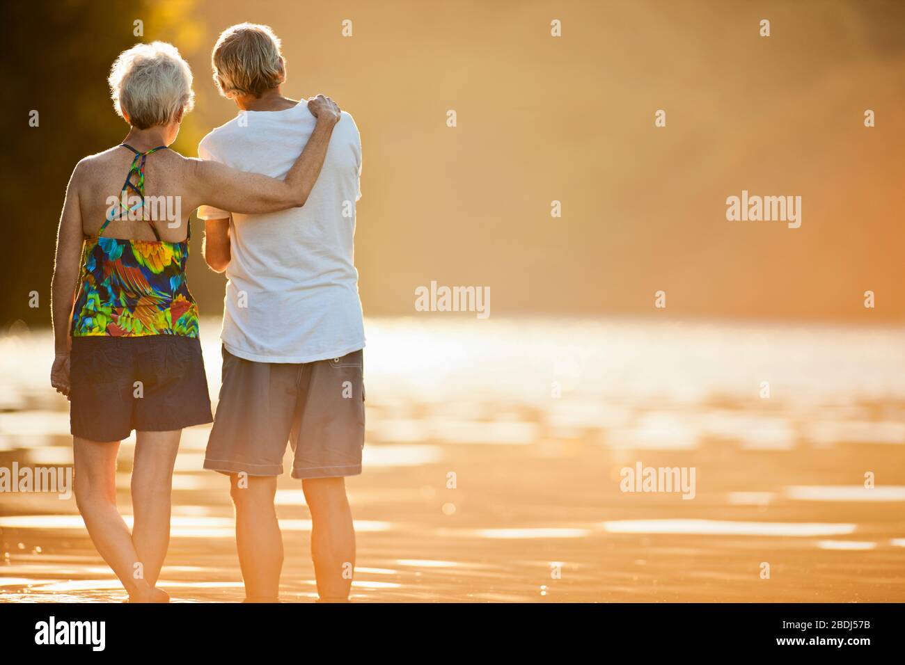 Buona coppia di anziani in piedi fianco a fianco da un lago Foto Stock