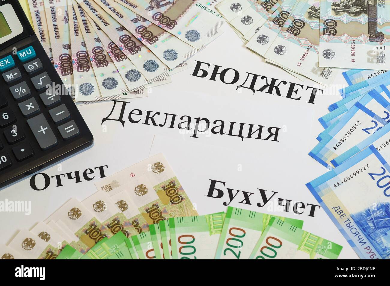 Sul tavolo sono presenti diverse bollette rubate e una calcolatrice. Il testo russo del bilancio. Dichiarazione. Rapporto. Contabilità" Foto Stock