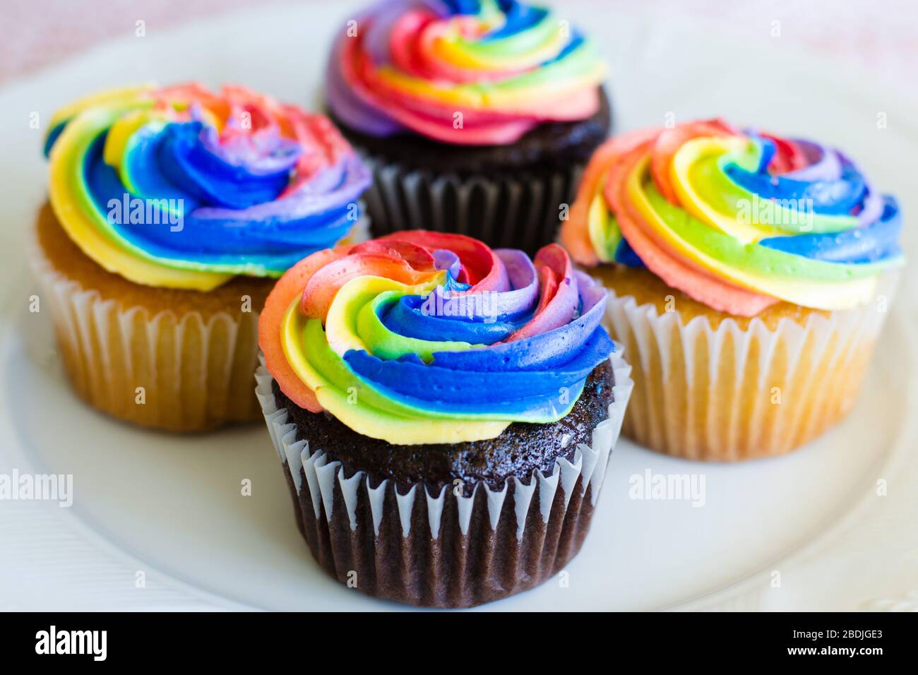 Cupcake al cioccolato e alla vaniglia con crema arcobaleno Foto Stock