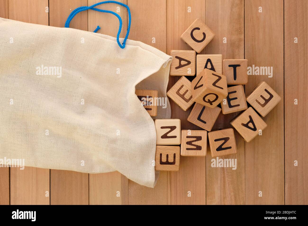 Borsa in tessuto e cubetti di legno vista dall'alto. Cubi in legno con lettere dell'alfabeto inglese, giochi educativi per bambini. Sacchetti di lino per riporre i giocattoli An Foto Stock