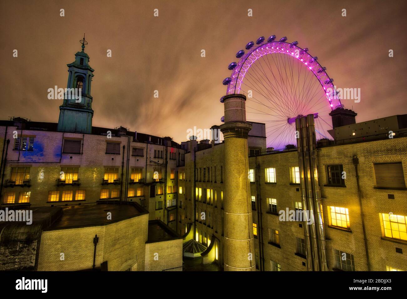 L'occhio londinese sorse sopra le pile di camini in una serata misteriosa, Southbank London, Inghilterra Foto Stock