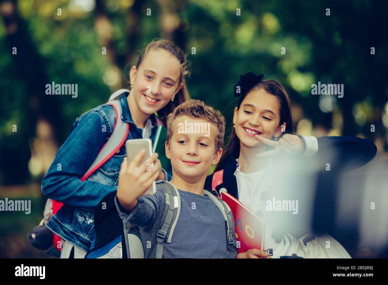 Ritratto di bambini felici della scuola che prendono selfie nel parco. Ritorno a scuola. Foto Stock