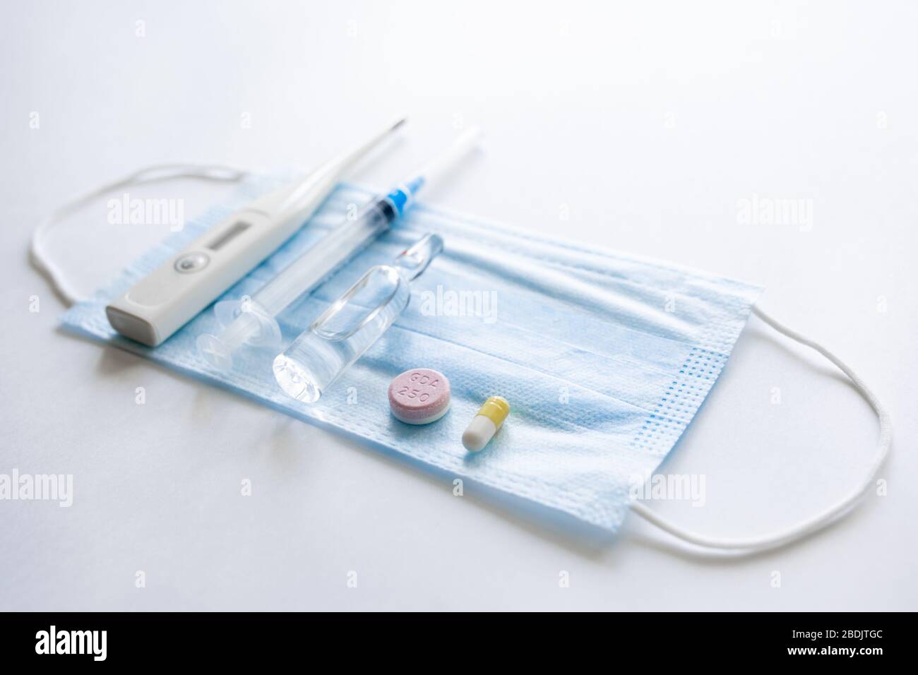 Maschera facciale monouso per uso medico, termometro, compressa rossa, compressa blu. Prevenzione del virus pandemico Covid-19. Quarantena, rimanere a casa. Maschera antivirale per la protezione contro l'influenza, le malattie da coronavirus. Foto Stock