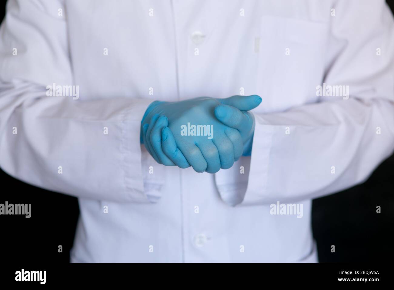 primo piano del medico. Guanti medici del chirurgo su sfondo nero. Foto Stock