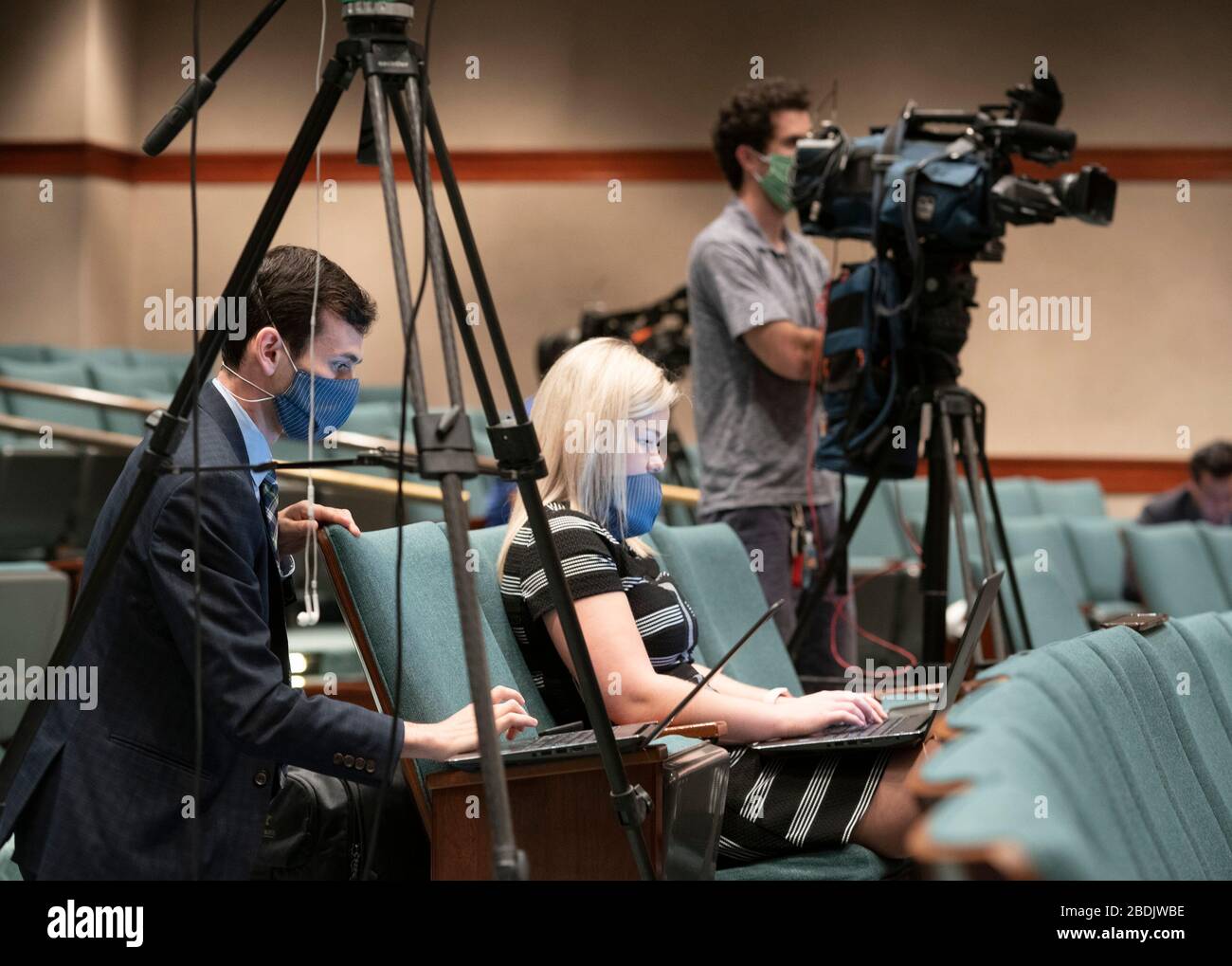 I membri della stampa, indossando maschere facciali protettive, ascoltano il governatore del Texas Greg Abbott che li informerà sulla crescente produzione volontaria di maschere facciali e schermi per rispondere alla crescente domanda di lotta contro l'epidemia di coronavirus. Foto Stock