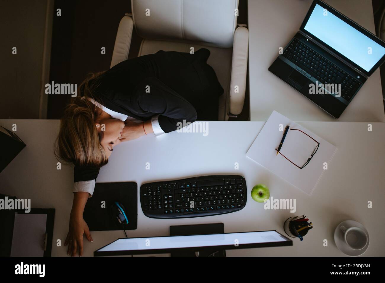 Stanco giovane bionda uomo d'affari caucasico che dorme in ufficio Foto Stock