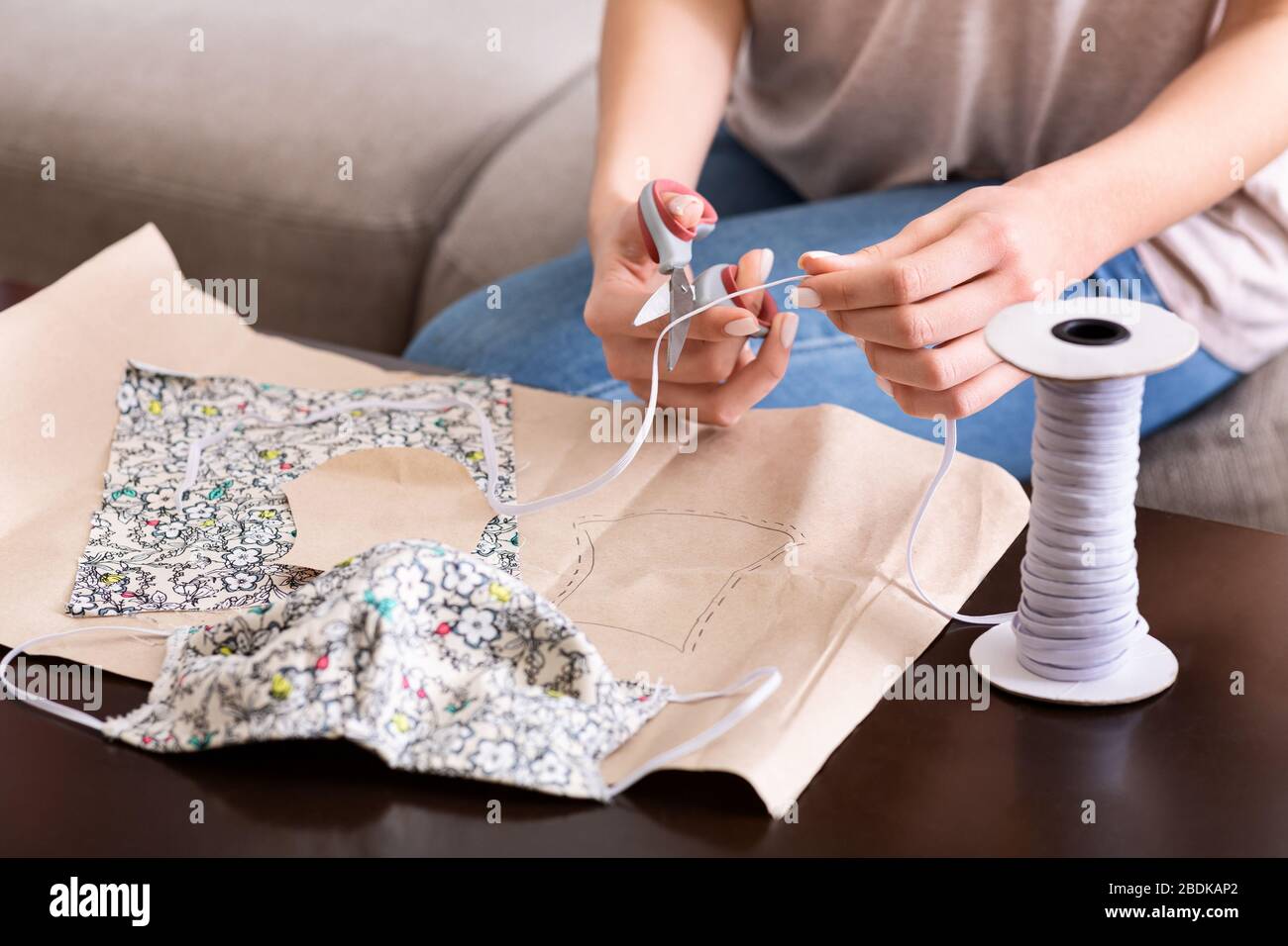 Prepari per epidemia. Ragazza fa maschera da materiali improvvisati Foto Stock