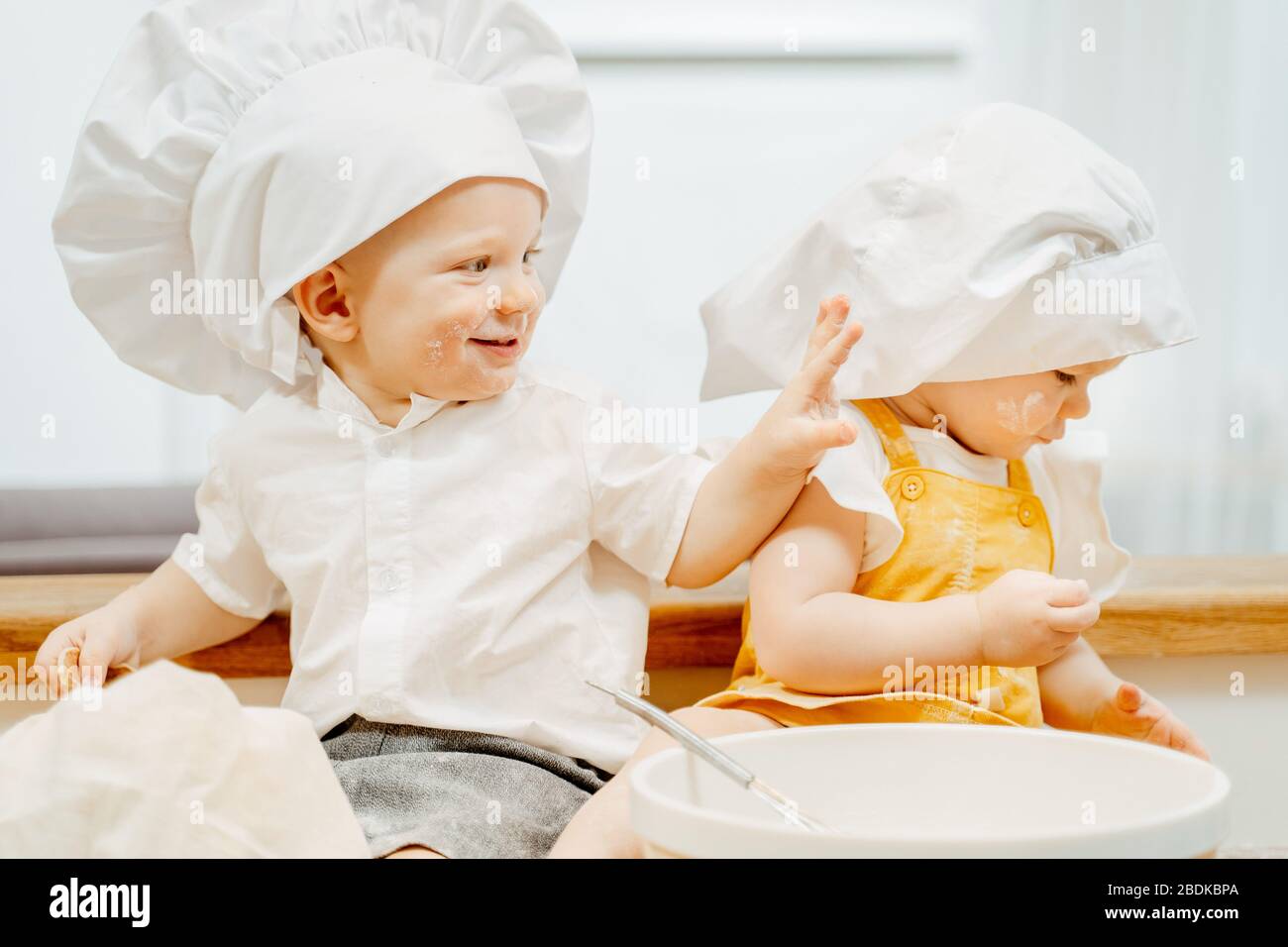Allegro piccolo caucasico allegro bambini in cappuccio bianco Foto Stock