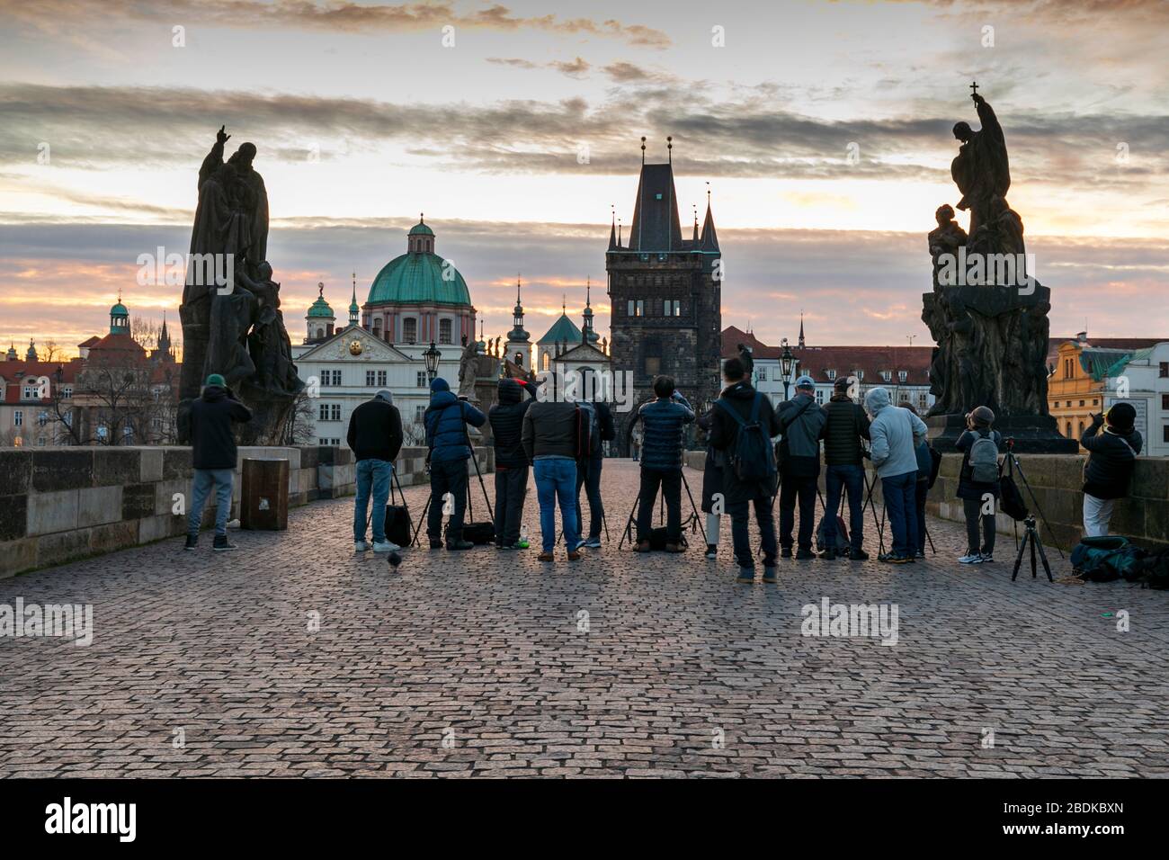 Un gruppo di fotografi pronti a catturare l'alba sul Ponte Carlo con le torri e le guglie della Città Vecchia oltre, Praga, Repubblica Ceca Foto Stock