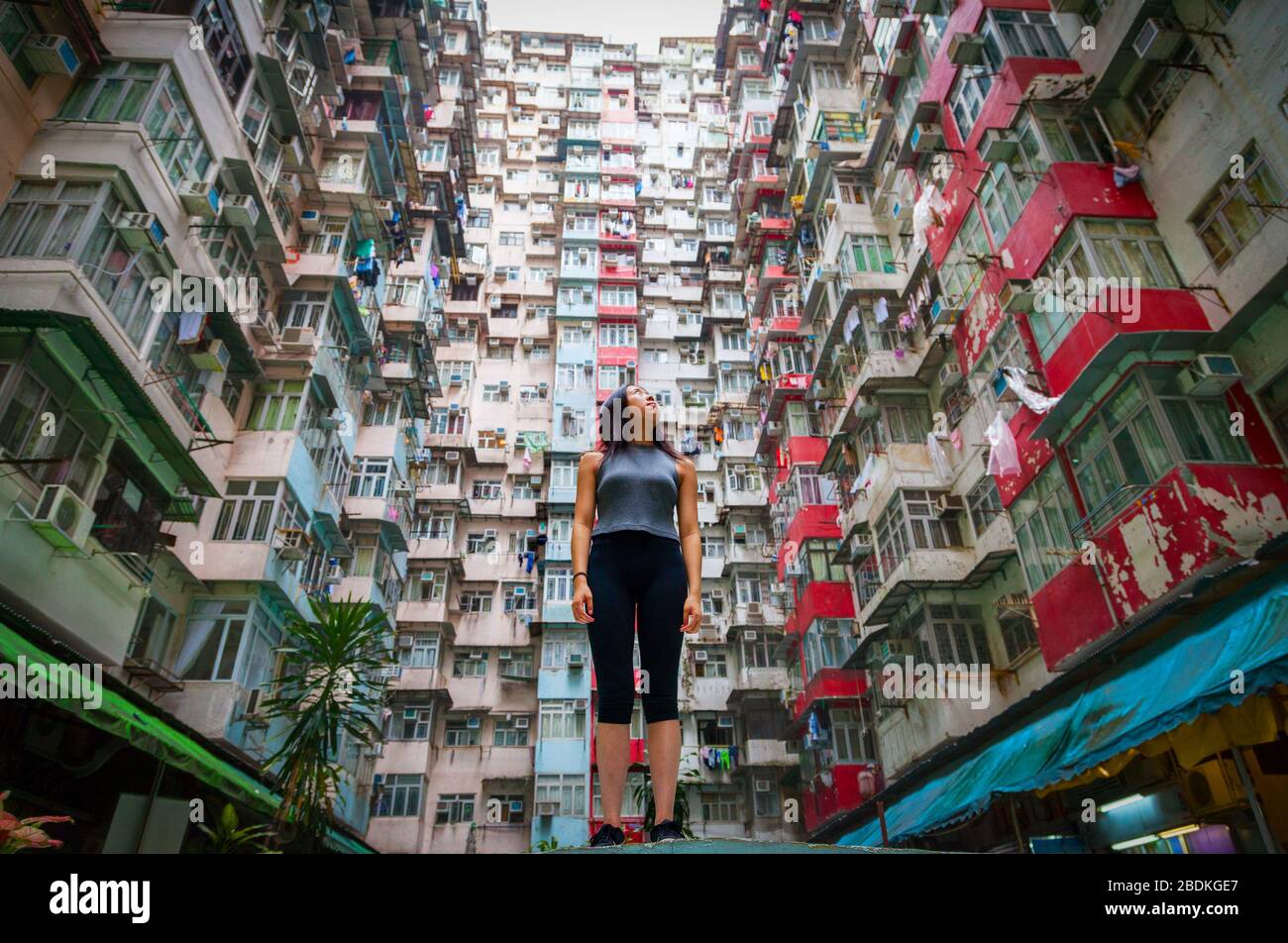 Ragazza cinese che guarda sul paesaggio urbano dei quartieri abitati di Hong Kong nella baia di Quarry, sull'isola di Hong Kong Foto Stock