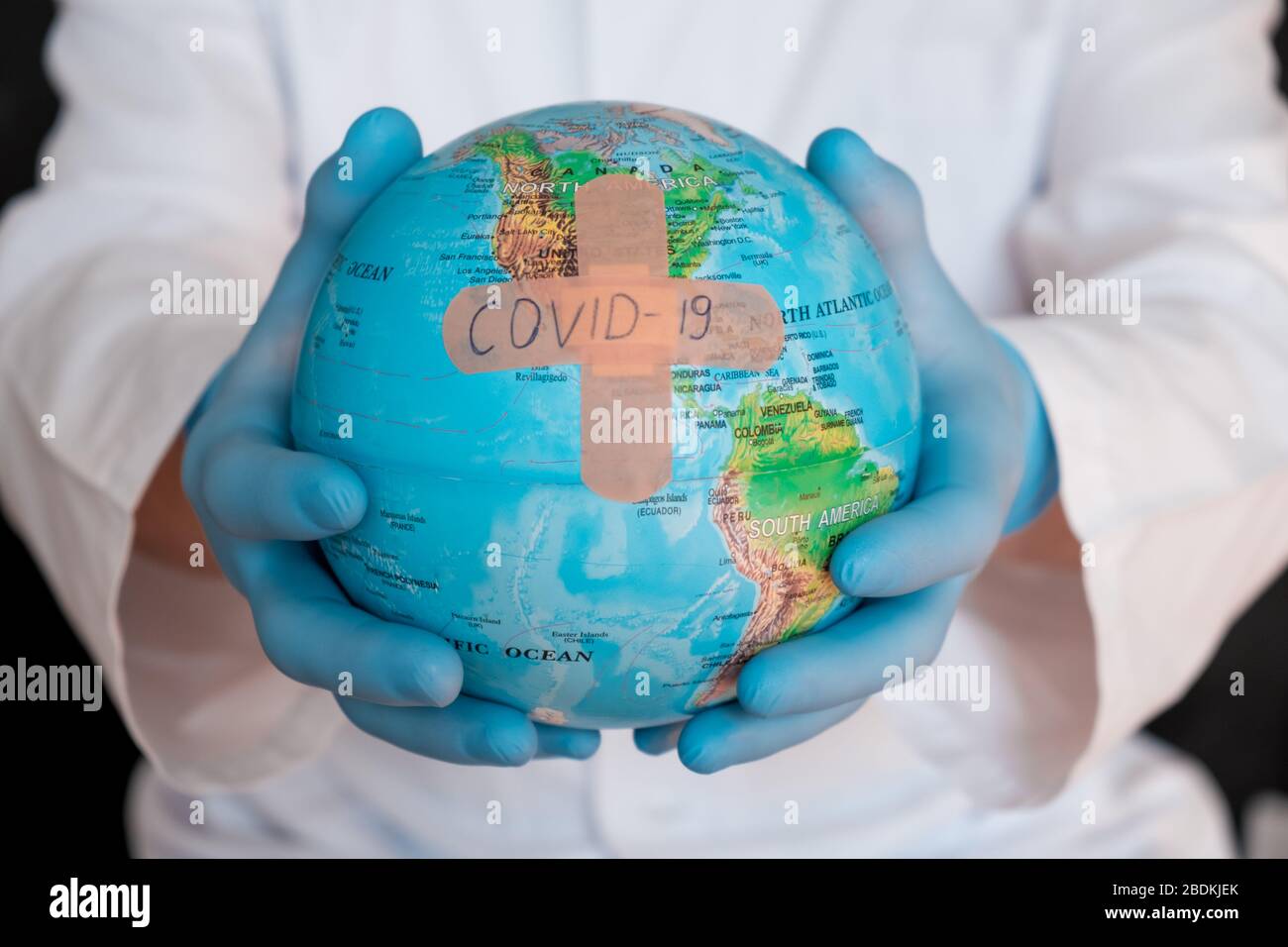 Globo mondiale con maschera medica verde su di esso. Concetto di epidemia di coronavirus. Concetto per la diffusione mondiale della disperazione di Coronavirus.. Foto Stock