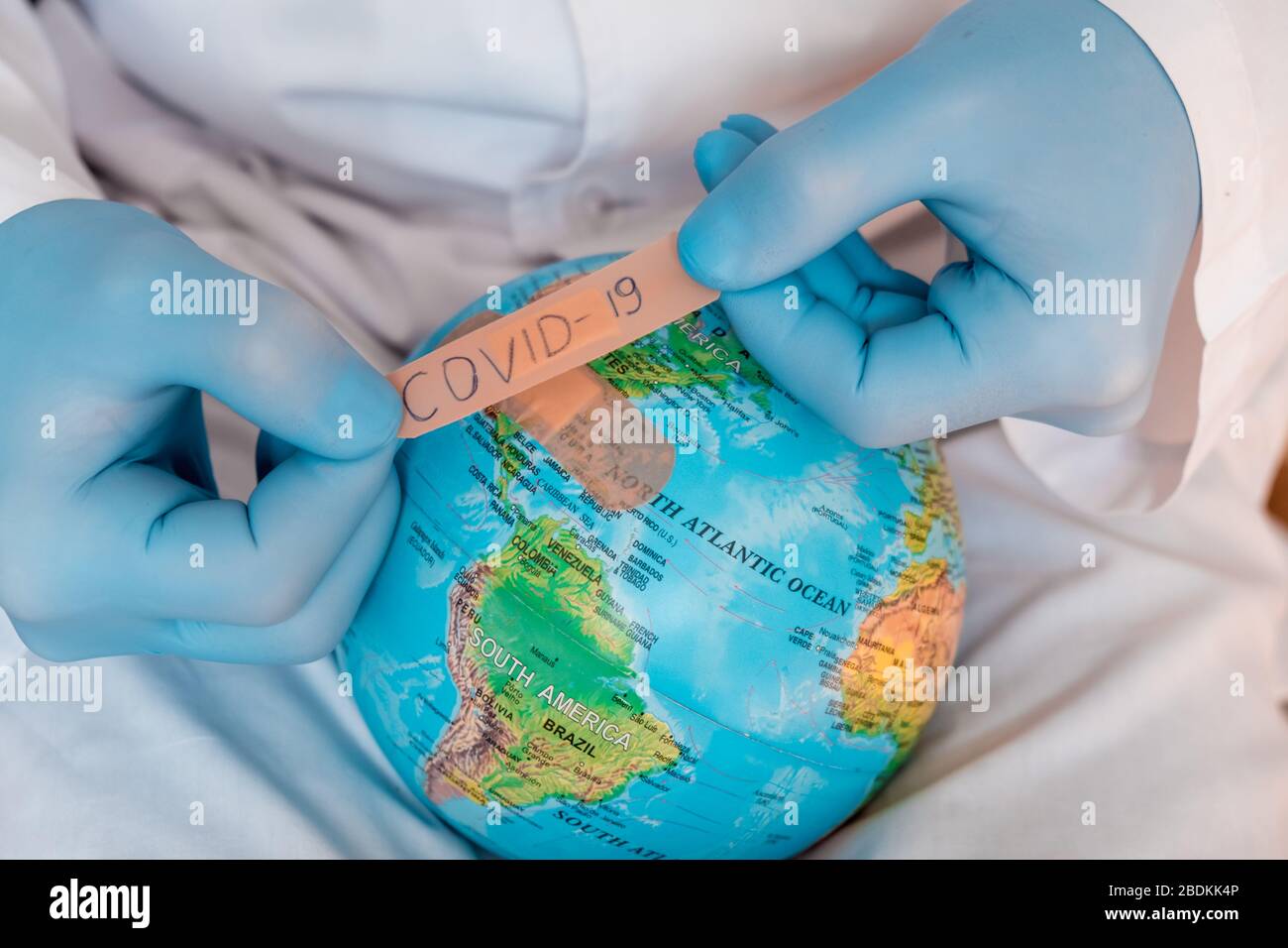 Globo mondiale con maschera medica verde su di esso. Concetto di epidemia di coronavirus. Concetto per la diffusione mondiale della disperazione di Coronavirus.. Foto Stock