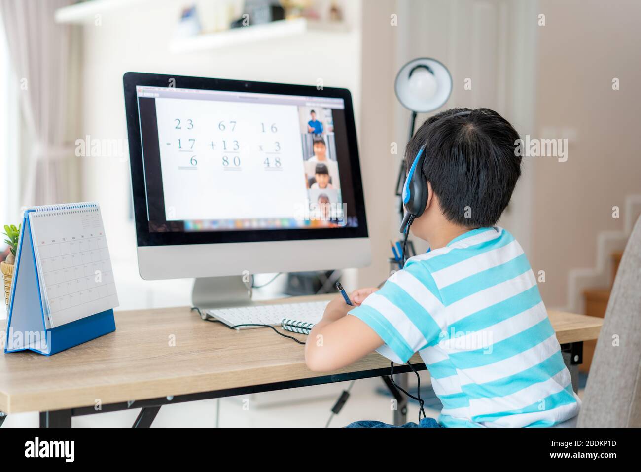 Asian boy studente video conferenza e-learning con insegnante e compagni di classe sul computer in soggiorno a casa. Homeschooling e apprendimento a distanza, onl Foto Stock