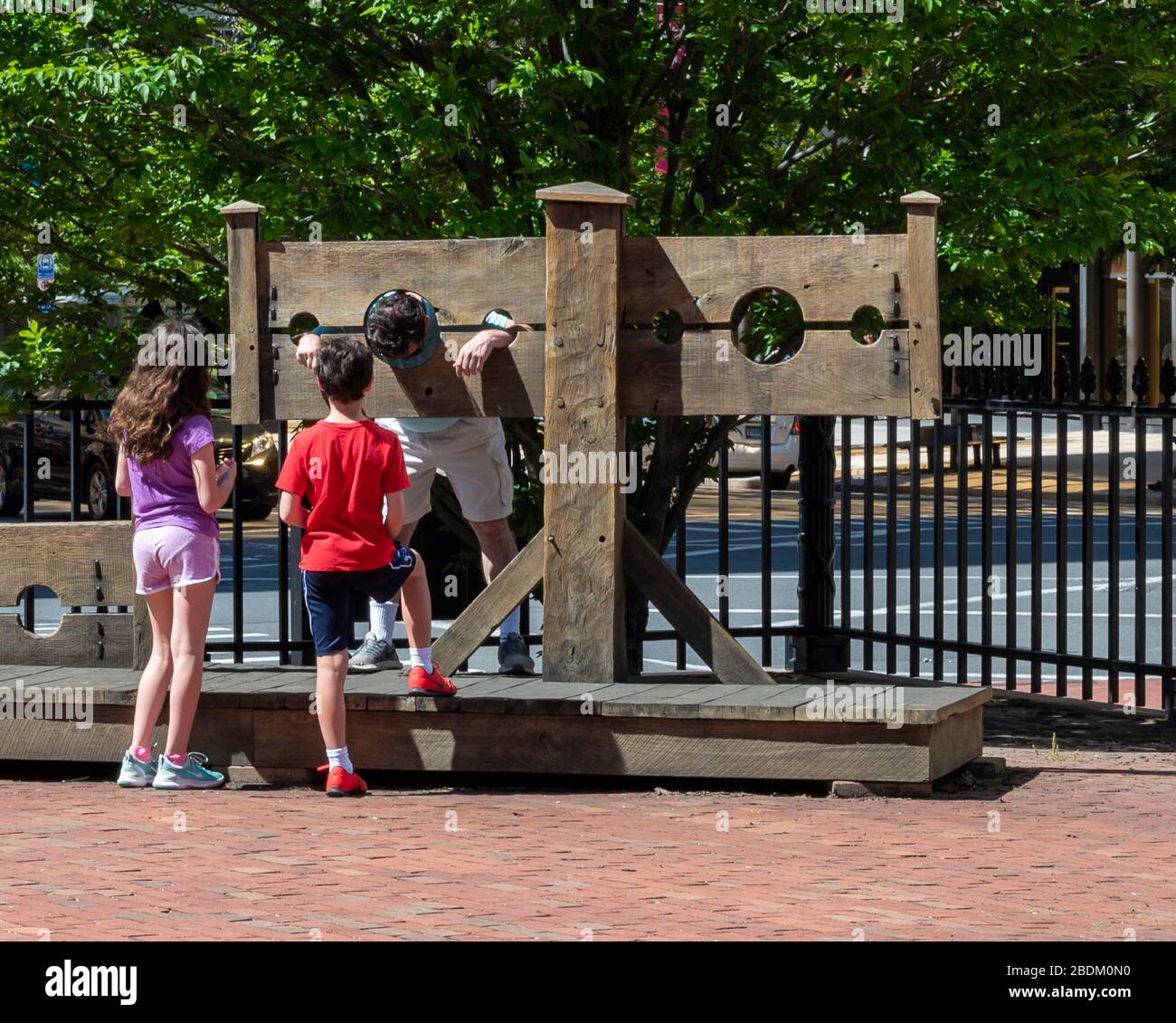 Due bambini, un ragazzo, e una ragazza in piedi davanti a un uomo in stock nel cortile della Old state House, nel centro di Hartford CT Foto Stock
