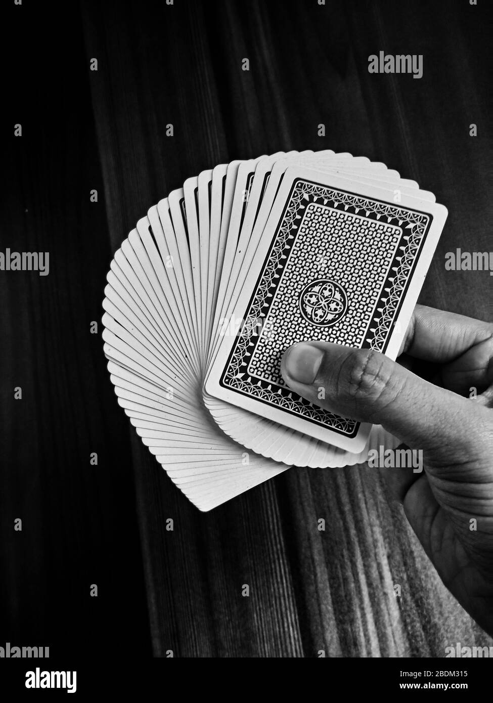 Giocare a carte in tavolo di legno bianco e nero godersi il gioco Foto Stock