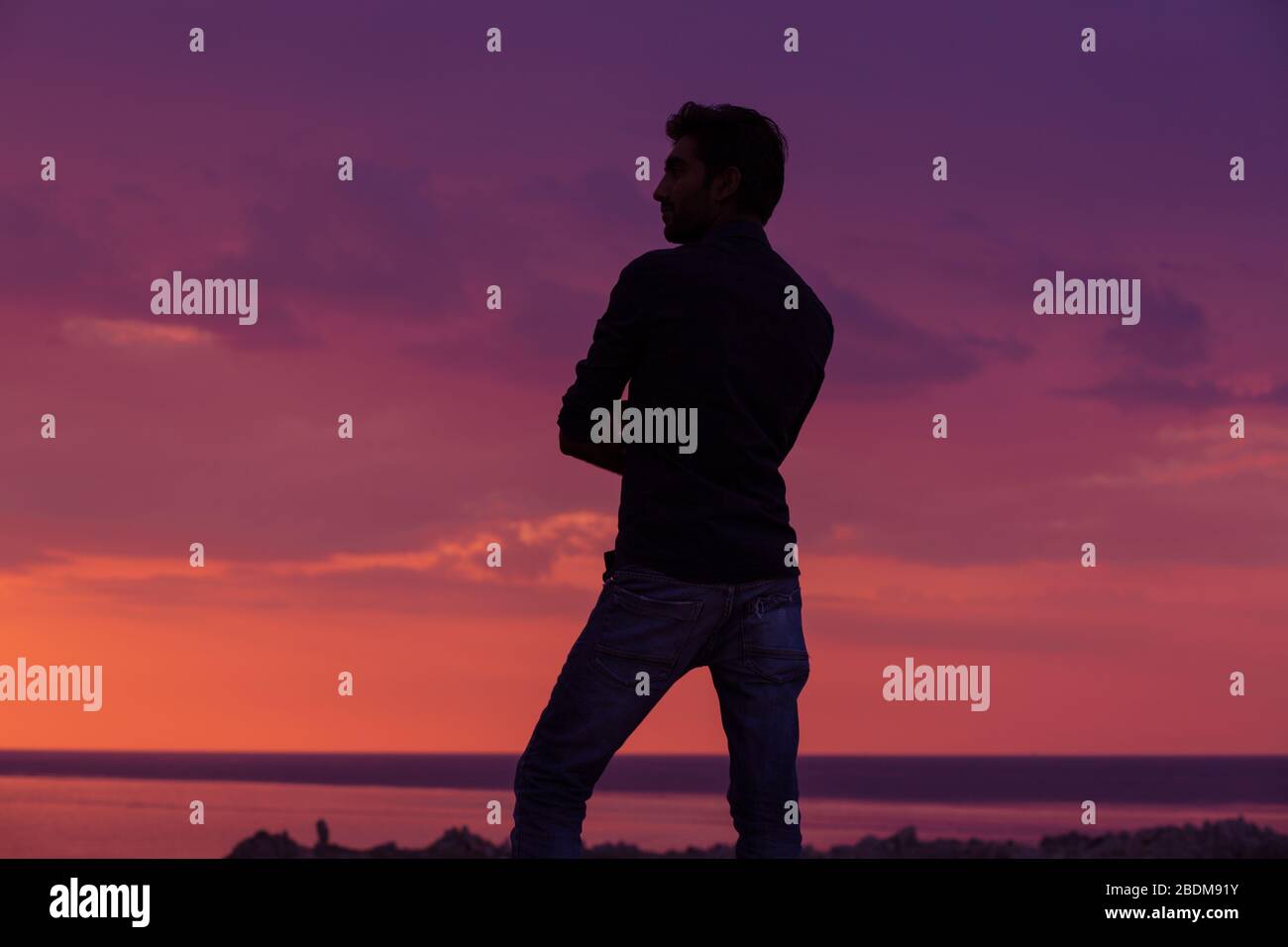 uomo d'affari in piedi di fronte al mare al tramonto, vista laterale profilo dell'uomo in piedi pensando al futuro sfondo all'aperto Foto Stock