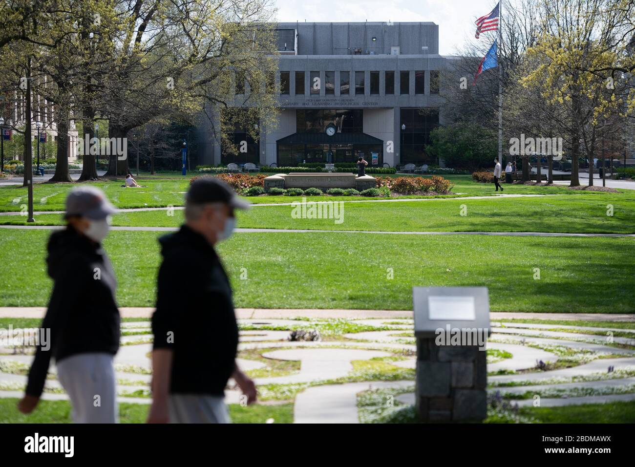 Washington, Stati Uniti. 8 aprile 2020. I pedoni che indossano le maschere attraversano il quadrilatero per lo più vuoto della American University (AU) a Washington, DC, il 8 aprile 2020, come si è visto in mezzo all'epidemia globale di coronavirus. Dato che i casi confermati hanno raggiunto i 1.5 milioni in tutto il mondo, con più di 400,000 solo negli Stati Uniti, i comunicati stampa hanno rivelato una risposta in ritardo da parte dell'amministrazione Trump nei primi giorni dell'epidemia. (Graeme Sloan/Sipa USA) Credit: Sipa USA/Alamy Live News Foto Stock