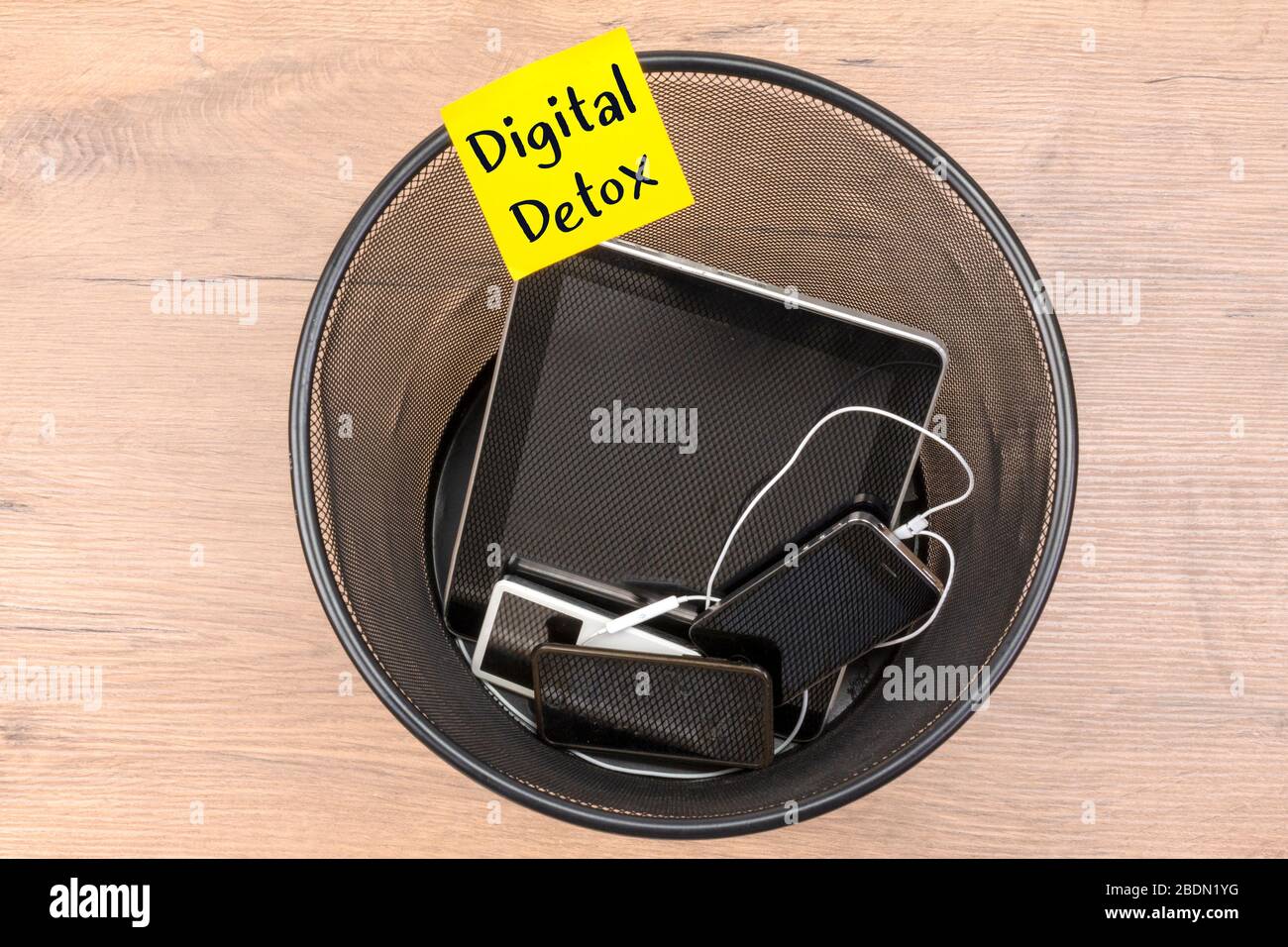 Messaggio di detox digitale su nota sul cestino dei rifiuti di dispositivi elettronici, tablet e smartphone, vista dall'alto. Foto Stock