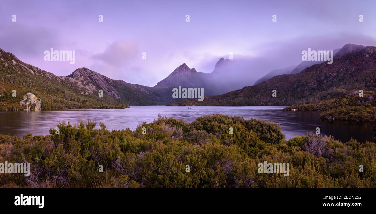 Spettacolare vista serale della flora di montagna intorno all'iconico Lago dove e al Monte Cradle coperto di nuvole sulla selvaggia costa occidentale della Tasmania. Foto Stock