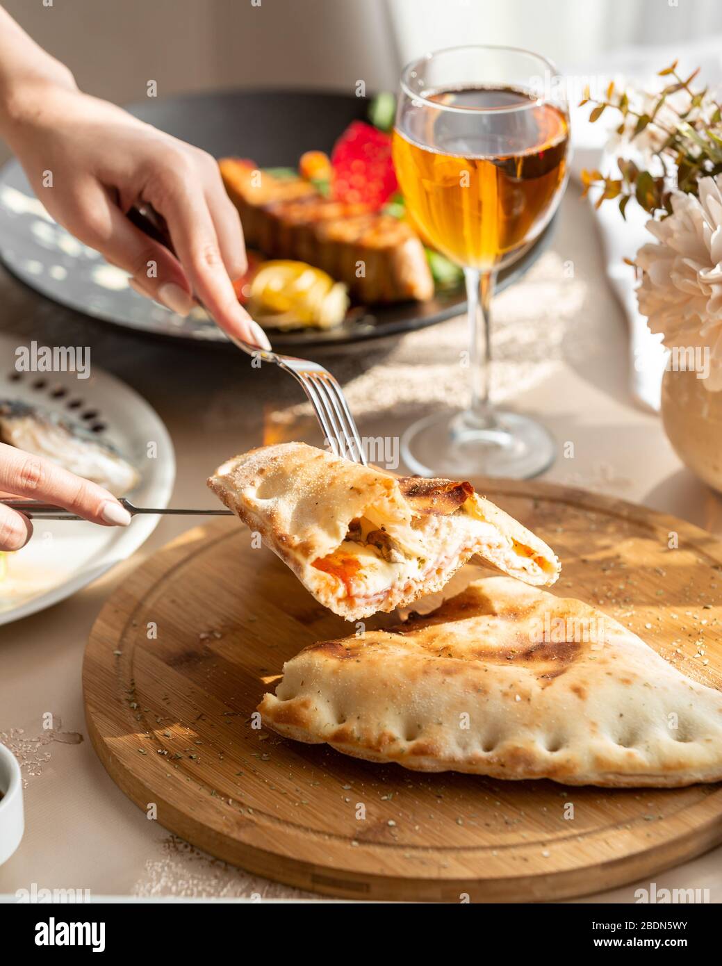 pane arioso ripieno di formaggio cremoso e carne su un asse di legno Foto Stock