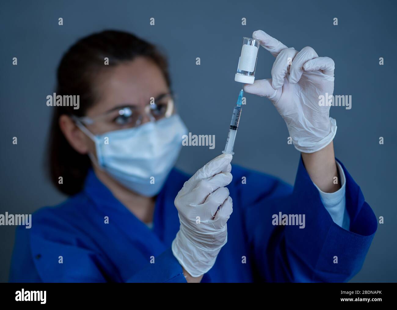 Vaccino contro il coronavirus COVID-19. Medico scienziato con siringa che analizza il virus Sars-cov-2 nella ricerca per il vaccino per essere pronto per la sperimentazione clinica. Femmina Foto Stock
