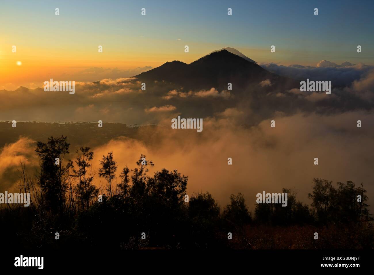 Vista panoramica di nuvole e la nebbia al tramonto dalla cima del monte Batur Kintamani (vulcano), Bali, Indonesia Foto Stock