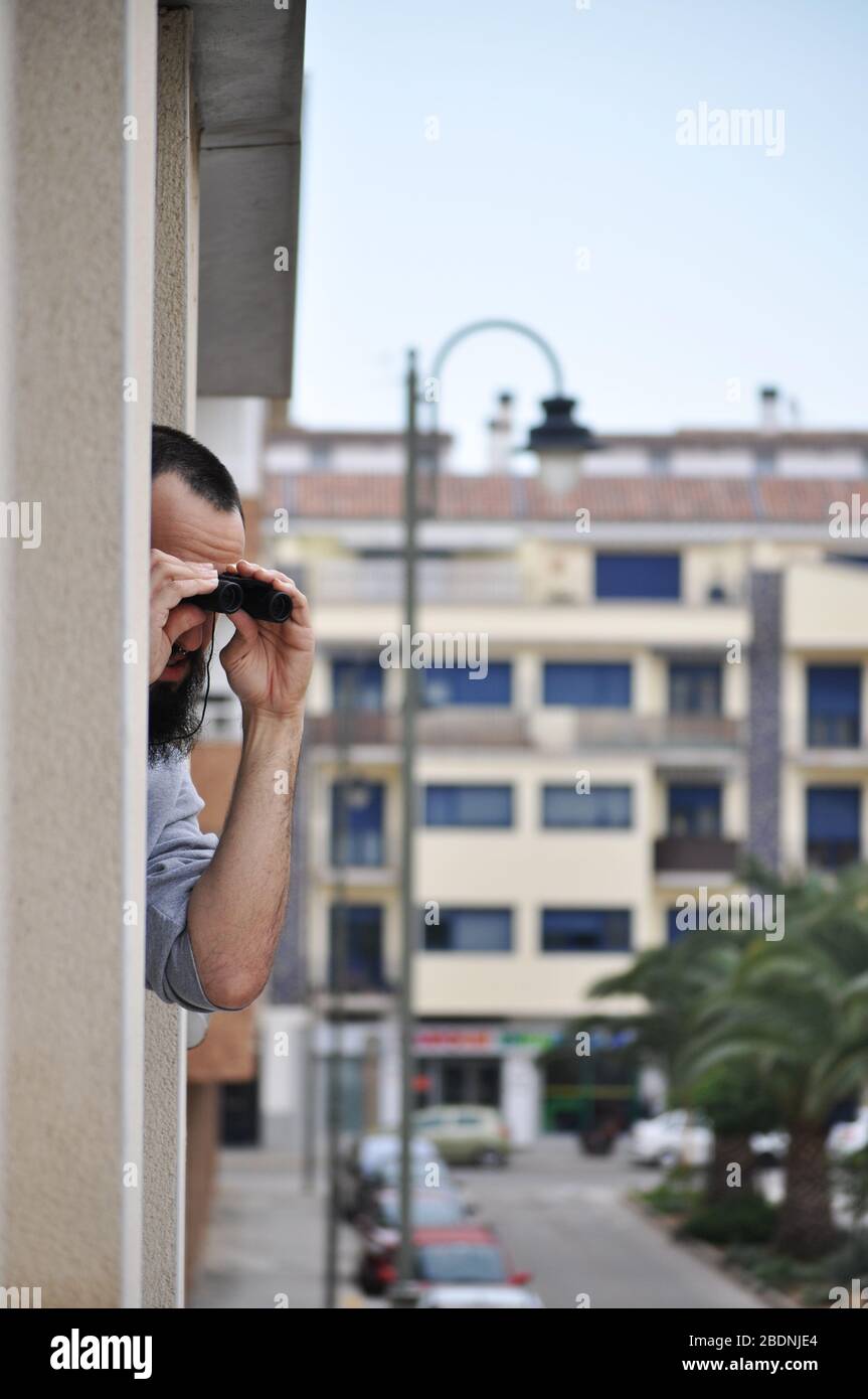 Uomo con il binocolo guardando fuori dalla finestra immagini e fotografie  stock ad alta risoluzione - Alamy