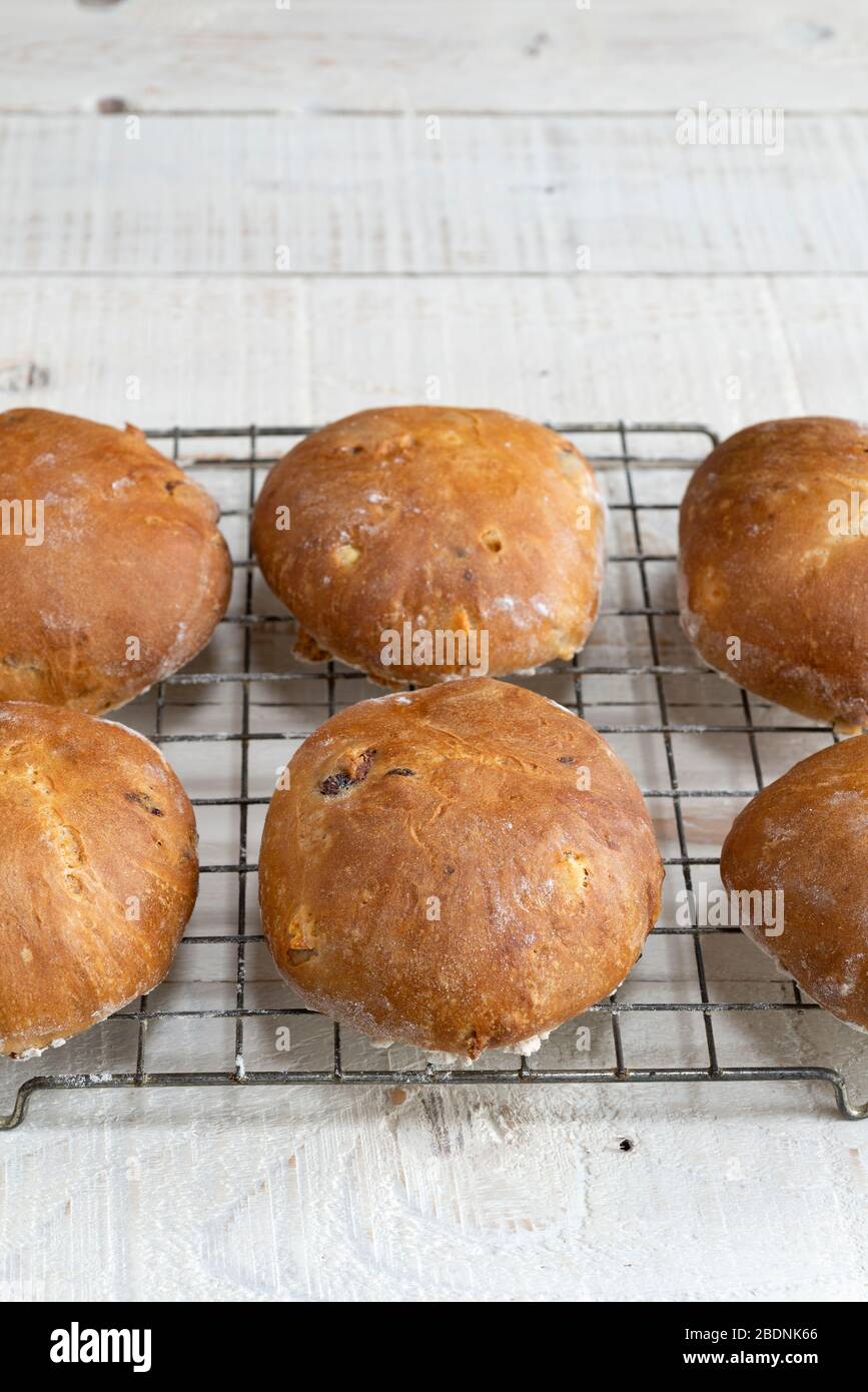 Teacakes di frutta con pasta soda appena sfornata, rinfrescati su una rastrelliera. Foto Stock